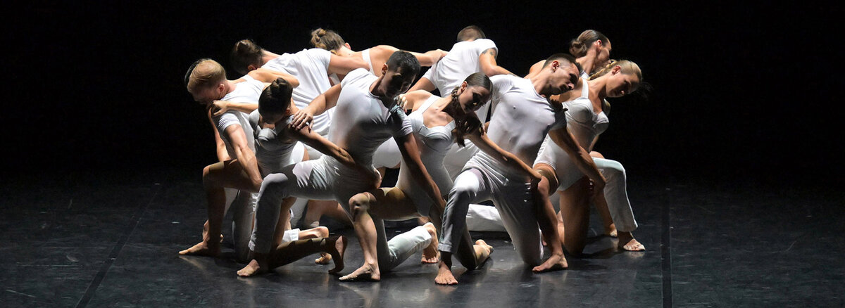 Gravity contemporary dance performance: a group of dancers in white on stage