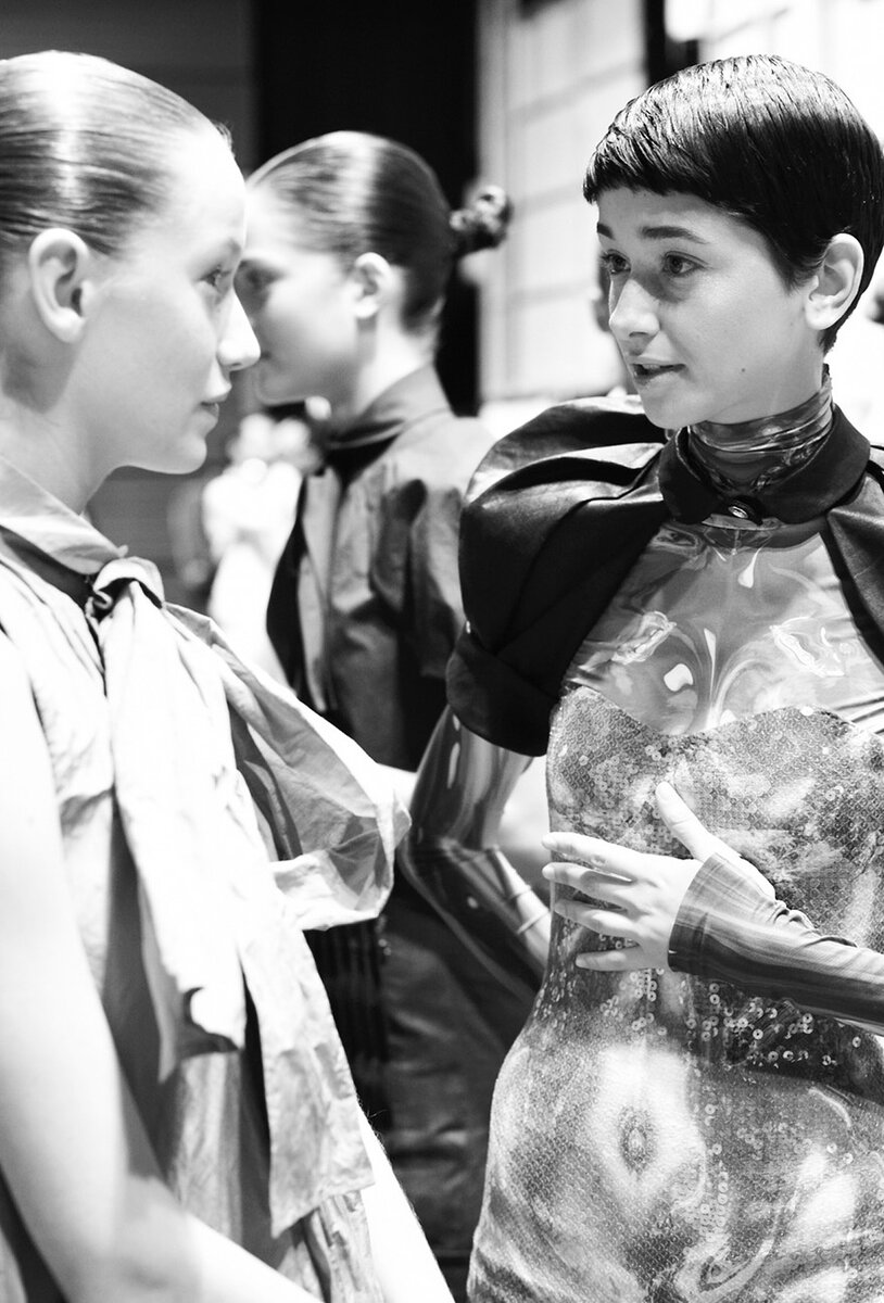 Backstage: models in sequin and translucent PVC looks with slicked-back hair