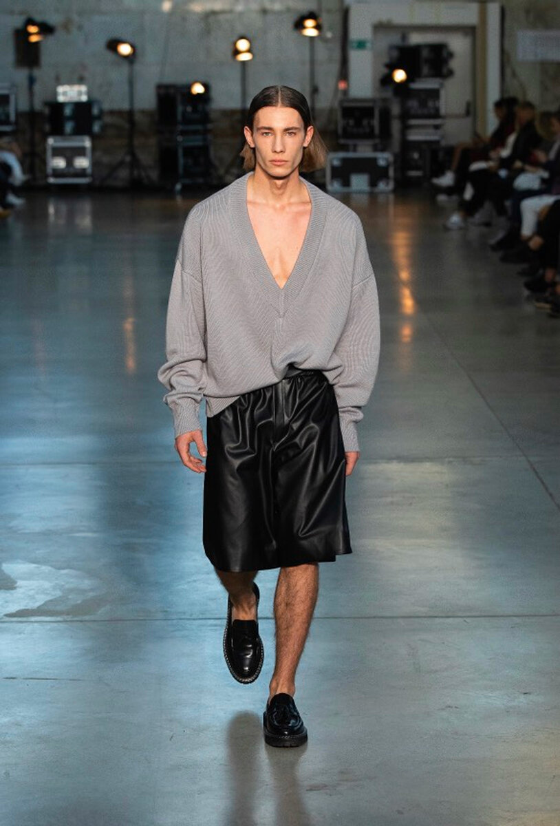 Runway look: oversized grey V-neck knit with black leather bermuda shorts and loafers
