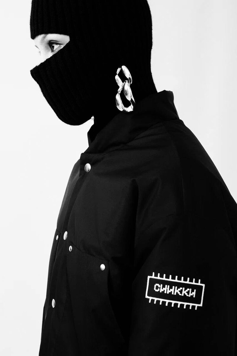 Black knit balaclava, chain earring and snap-front hooded jacket with Siikki logo