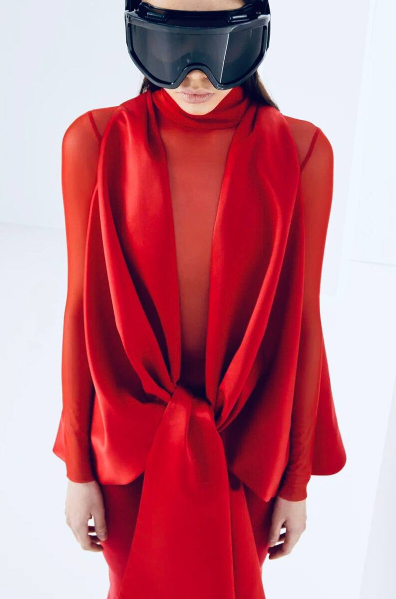 Model in artsy red dress worn with black ski goggles